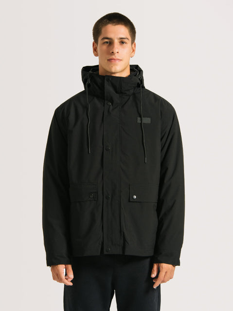 Homem vestindo Jaqueta pesada preta 3 em 1, com capuz ajustável e bolsos frontais com botões, projetada para proteção em condições frias e chuvosas.