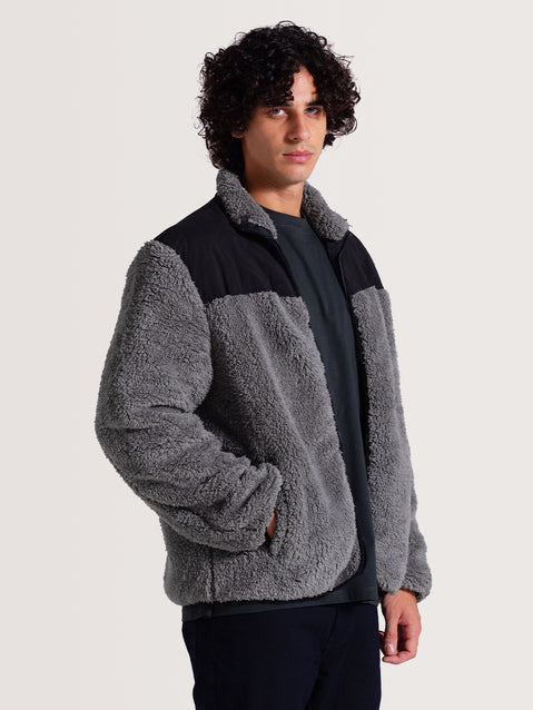 Homem vestindo jaqueta pesada preta 3 em 1 com forro cinza de lã aparente, mangas compridas e estilo casual, ideal para conforto.