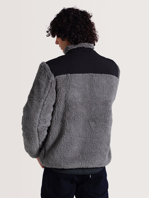 Homem de costas usando uma jaqueta pesada preta 3 em 1, com forro cinza de lã pelúcia e detalhe preto nos ombros, ideal para clima frio.