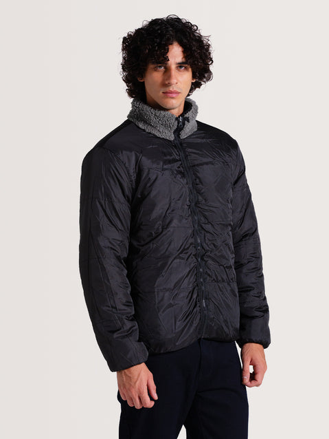 Homem vestindo a jaqueta pesada preta 3 em 1, com tecido externo acolchoado, gola alta de lã cinza e design funcional.