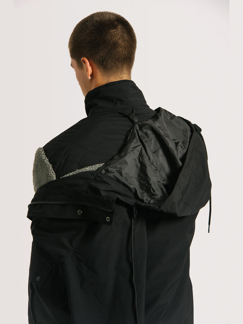 Jaqueta pesada preta 3 em 1, com parte externa removível e interior acolchoado visível, destacando seu design funcional e versátil.