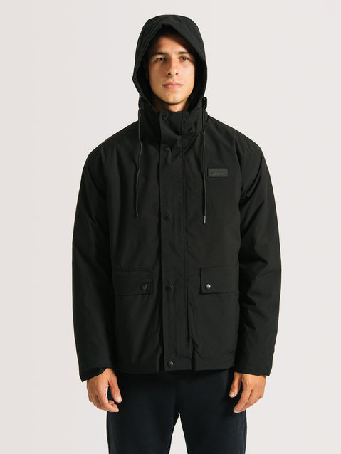 Homem vestindo a jaqueta pesada preta 3 em 1, com capuz ajustável, fechamento por botões e bolsos frontais.