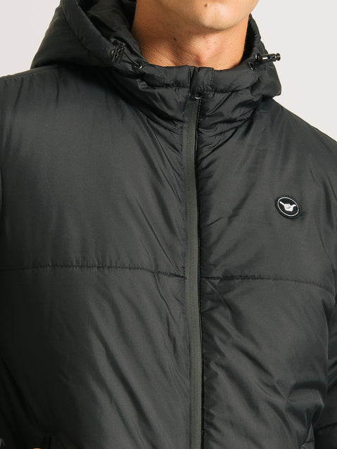 Close da jaqueta puffer preta com capuz ajustável, zíper frontal e um pequeno emblema no lado esquerdo do peito. Tecido liso e fosco.