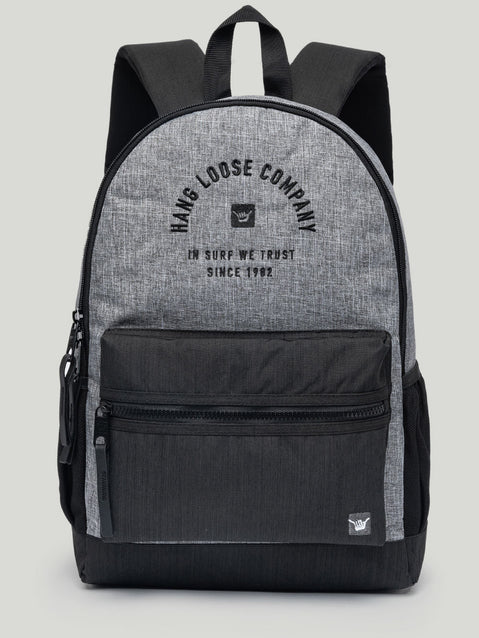 Mochila Hang Loose cinza e preta com bolso externo, alças acolchoadas e estampa frontal “In Surf We Trust – Since 1982”. Estilo casual e funcional.