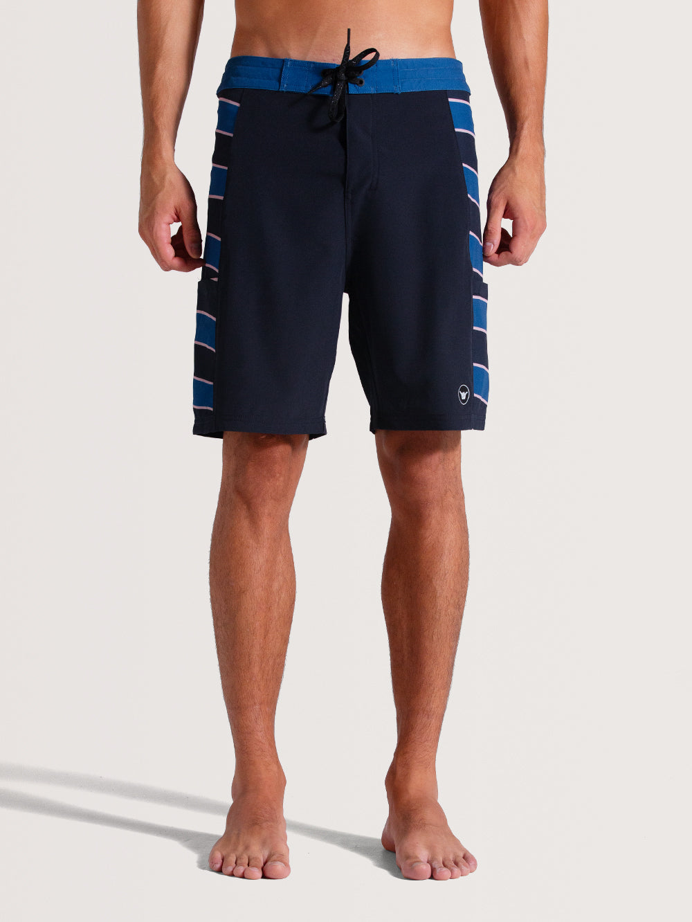 Homem vestindo boardshorts 19 polegadas chumbo com cós azul contrastante, listras laterais em azul e branco, ajuste por cordão preto e design casual.