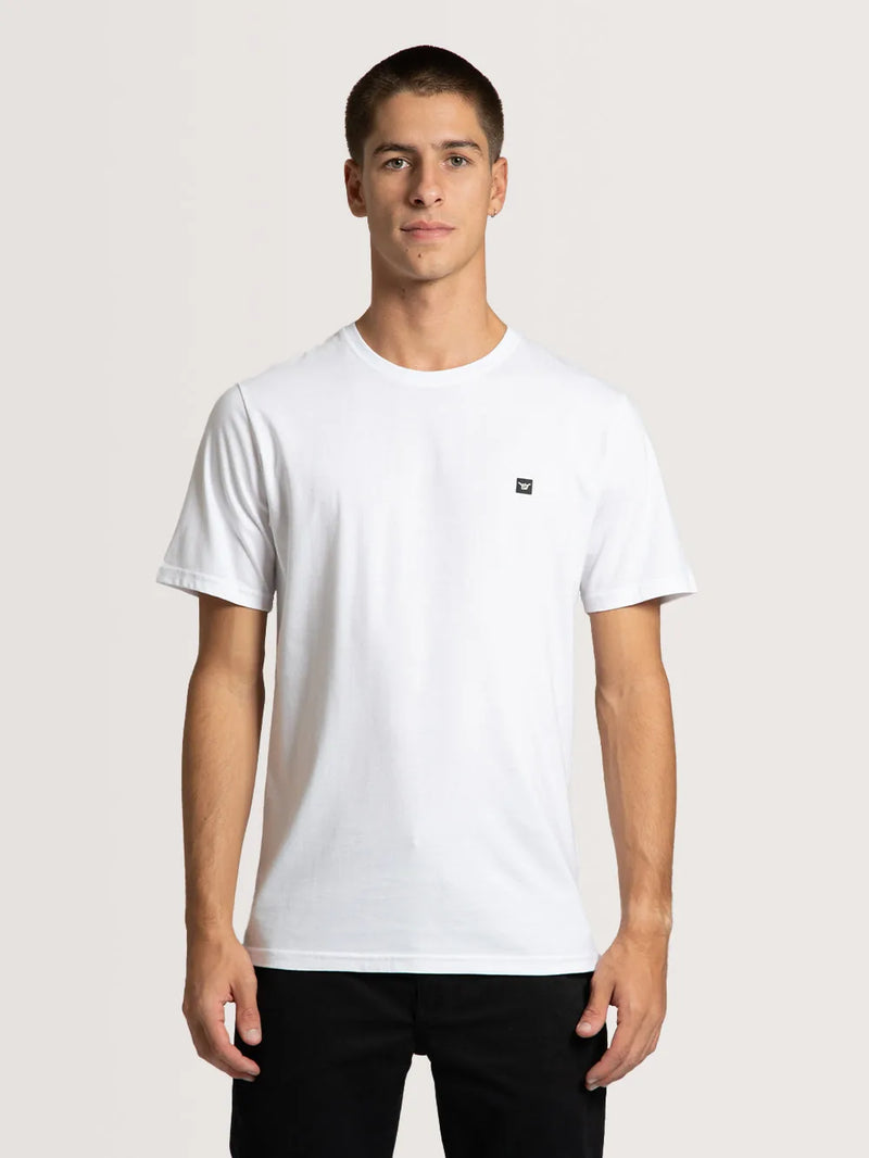 Modelo vestindo a camiseta especial Hang Loose classic na cor branca com pequeno símbolo shaka no peito.