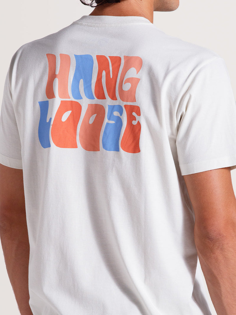 Camiseta off white básica manga curta com estampa traseira "Hang Loose" estilizada em azul e laranja vibrantes.