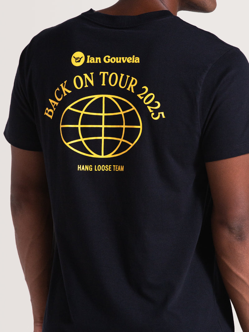 Homem vestindo uma camiseta preta de manga curta da Hang Loose com estampa amarela nas costas: “Ian Gouveia”, “Back On Tour 2025” e desenho de um globo.