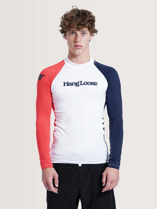 Modelo vestindo a camiseta surf manga longa branca. Na parte frontal da peça há o home da marca escrito em azul.