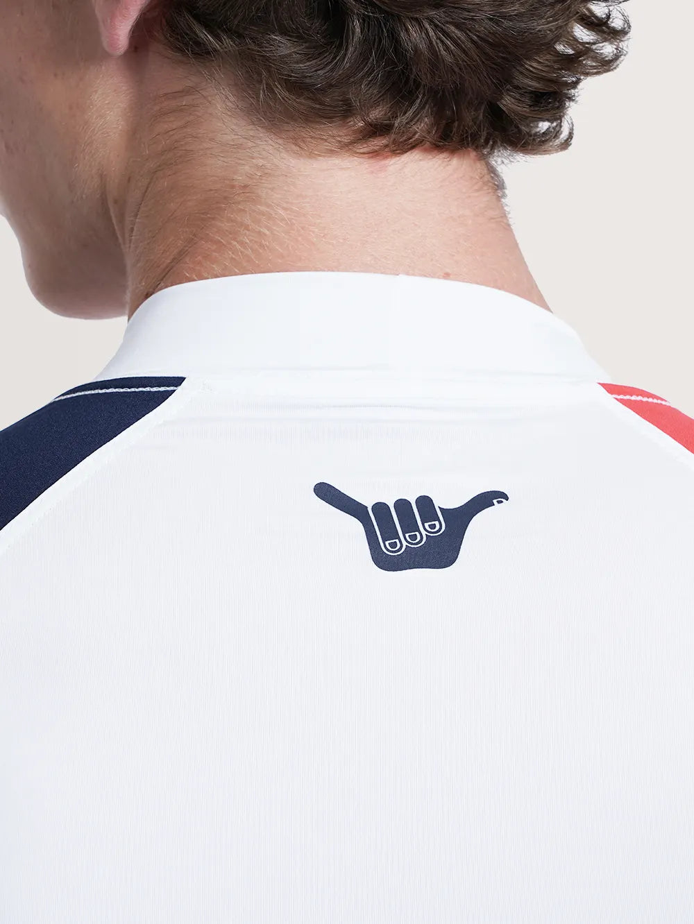 Imagem detalhada do logo Hang Loose na parte superior das costas da camiseta surf manga longa branca.