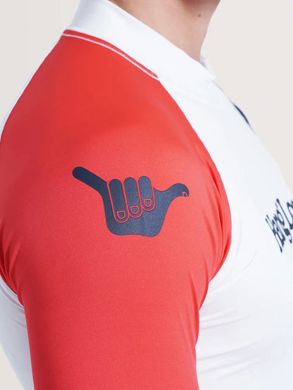 Imagem do ombro direito da camiseta surf manga longa branca, que possui cor vermelha e símbolo Hang Loose em azul.
