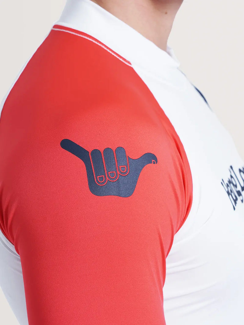Imagem do ombro direito da camiseta surf manga longa branca, que possui cor vermelha e símbolo Hang Loose em azul.