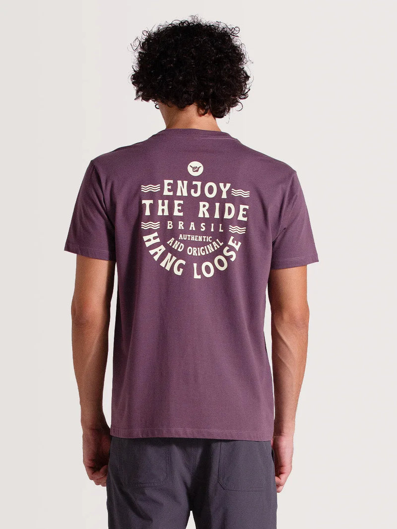 Parte de trás da camiseta violeta manga curta Com logo shaka e escrita "Enjoy The Ride, Authentic and Original Hang Loose" em branco. Design moderno.