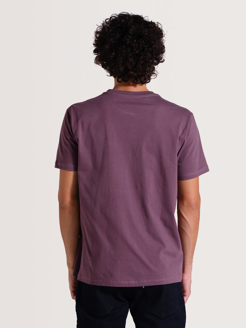 Parte de trás da camiseta violeta manga curta, em design simples e liso, com caimento reto e acabamento básico na gola e nas mangas.