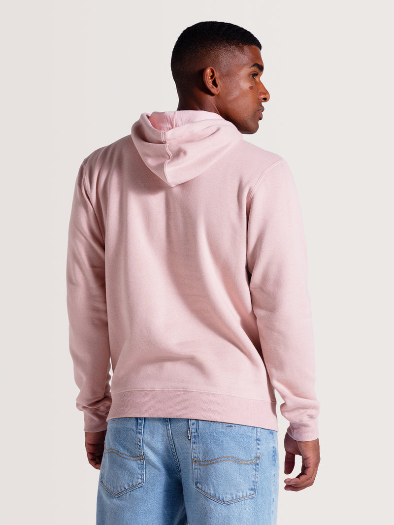 Homem de costas vestindo o moletom canguru rosa com capuz e acabamento simples, combinado com jeans azul claro.