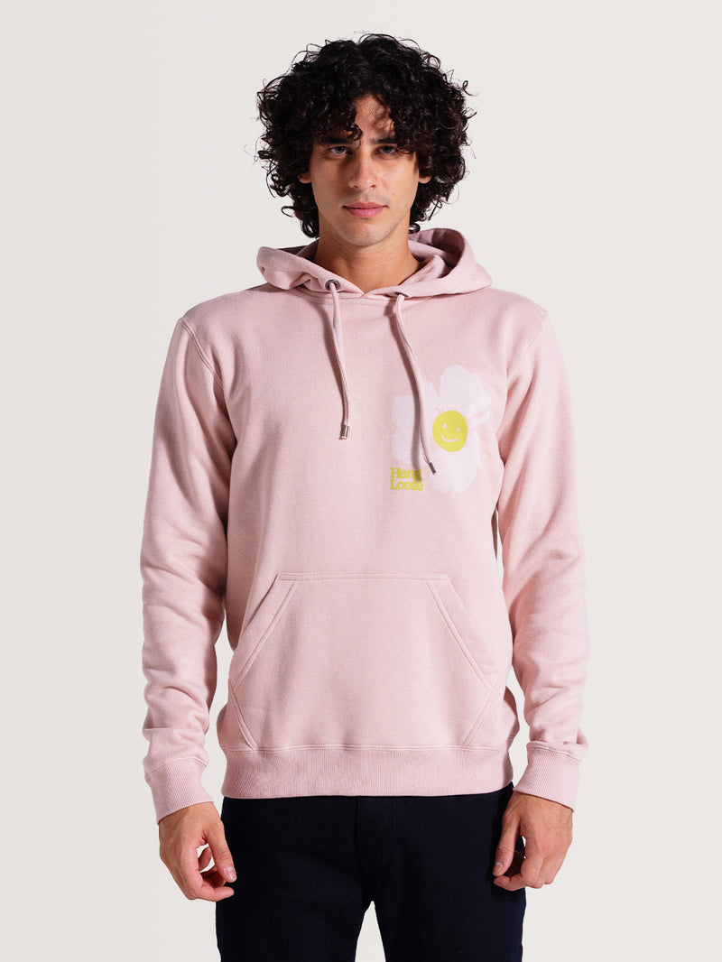 Moletom canguru rosa venice com capuz ajustável por cordão, bolso frontal, flor branca com smile amarelo estampado no peito. Design casual e descontraído.
