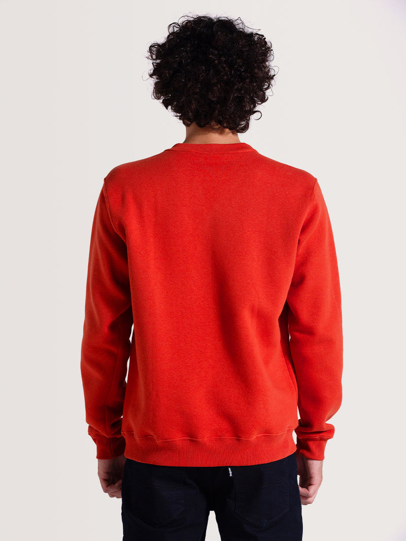 Homem de costas vestindo moletom careca vermelho felpado com gola redonda e tecido liso. Combinado com calça preta casual.