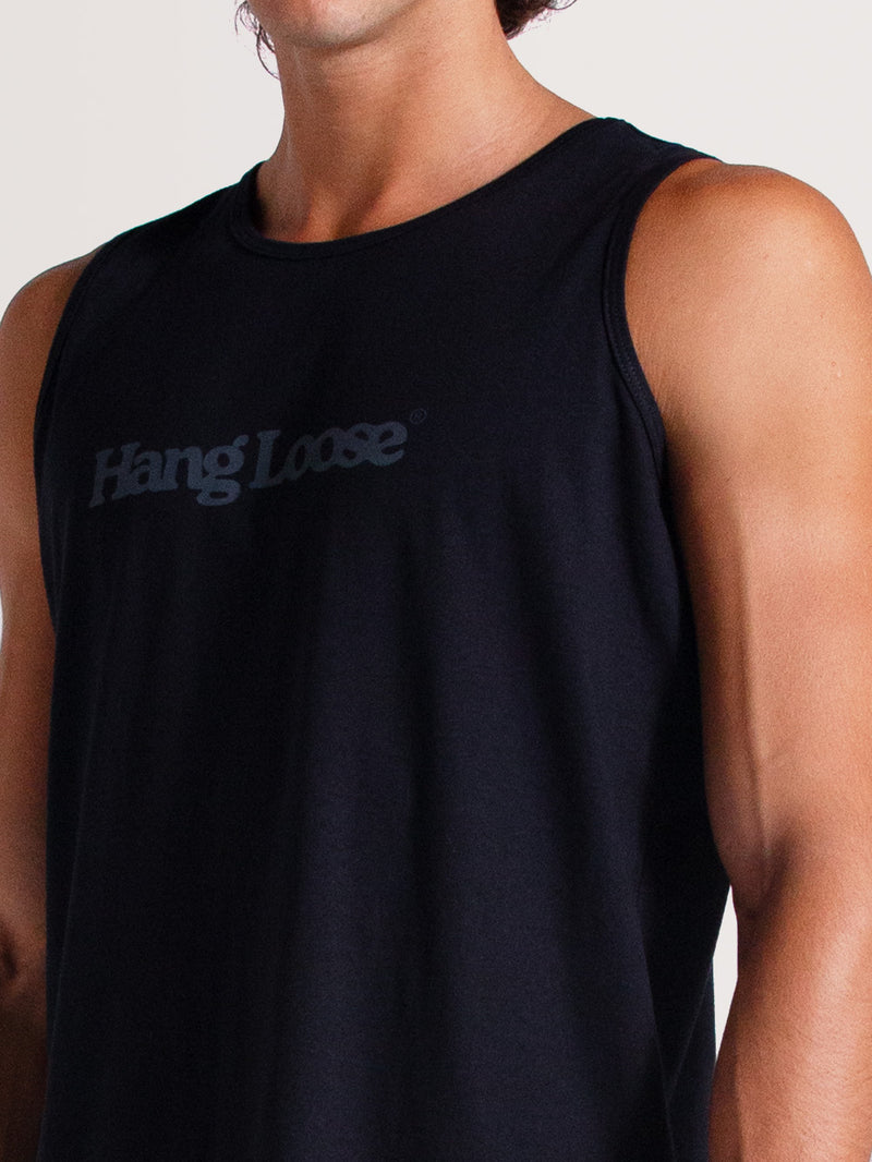 Homem vestindo regata preta básica com logo "Hang Loose" em tom cinza no peito, sobre fundo neutro claro.